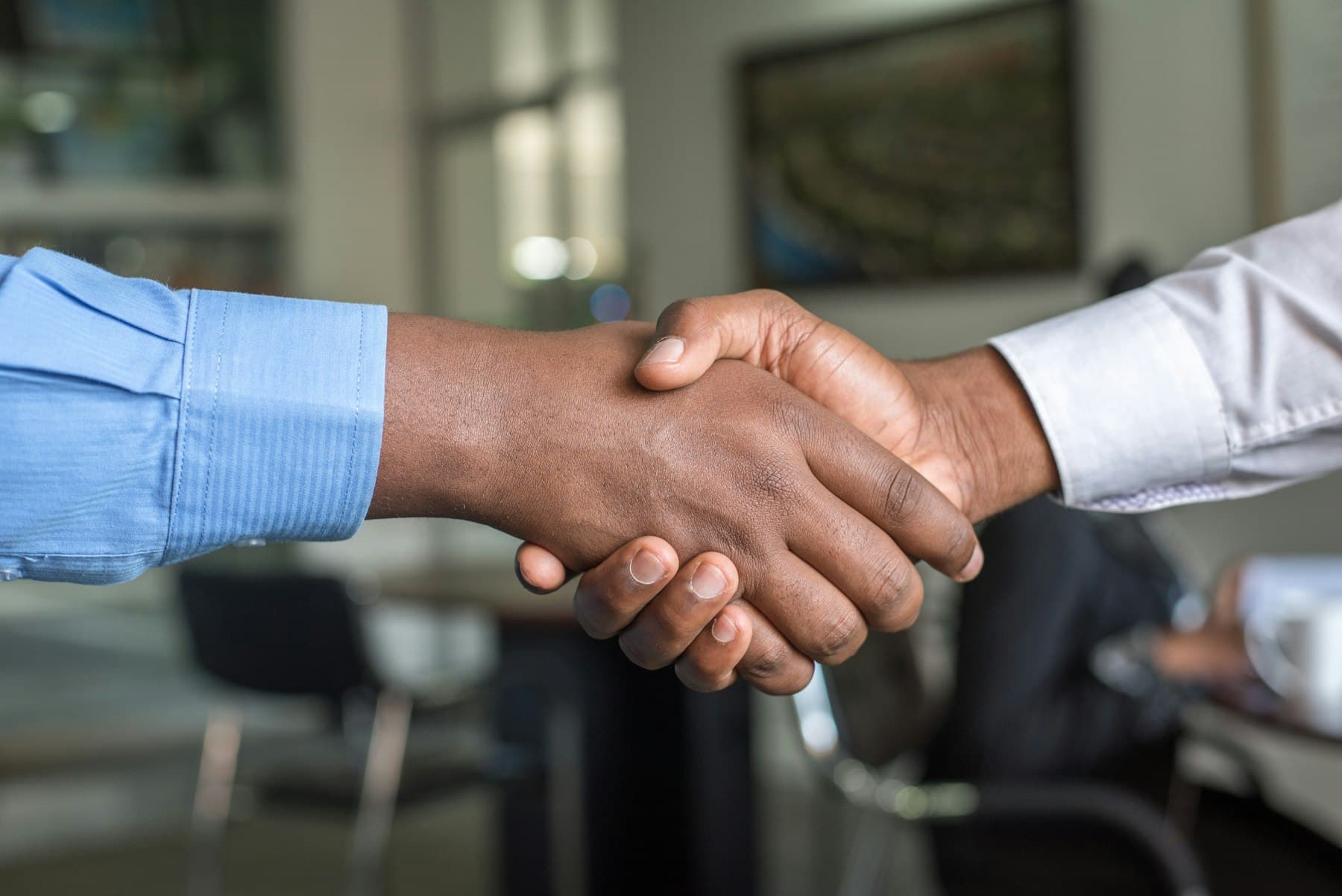 Poignée de main chaleureuse entre un recruteur et un candidat après un entretien réussi